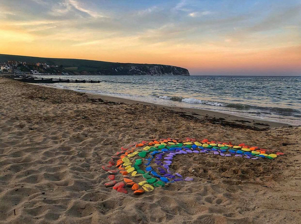 Rainbow made out of pebbles on Swanage Beach