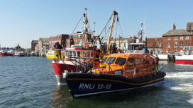 Swanage lifeboat in Poole Harbour with rescued fishing boat