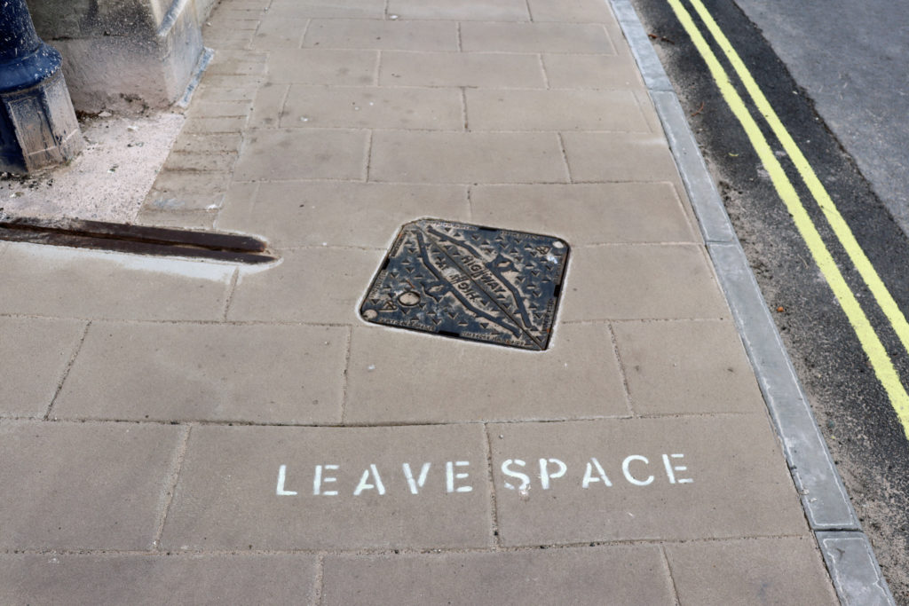 'leave space' sign on a pavement