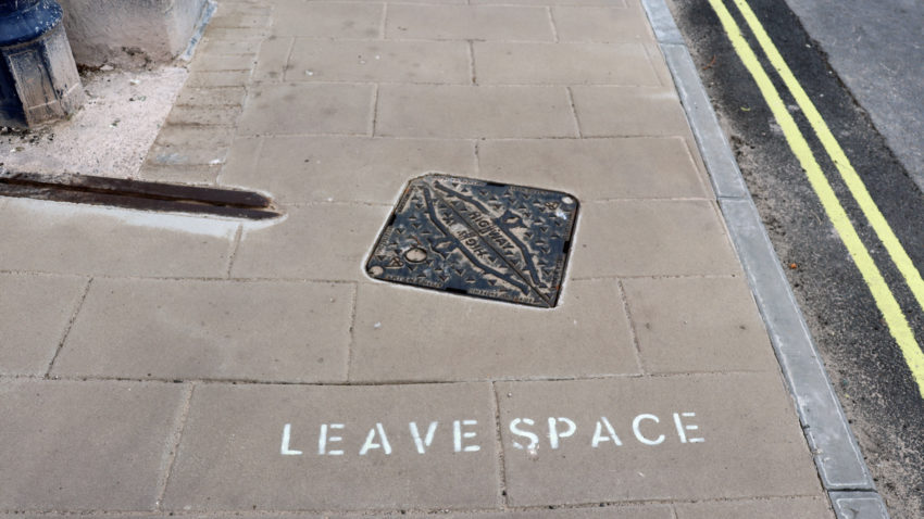 'leave space' sign on a pavement