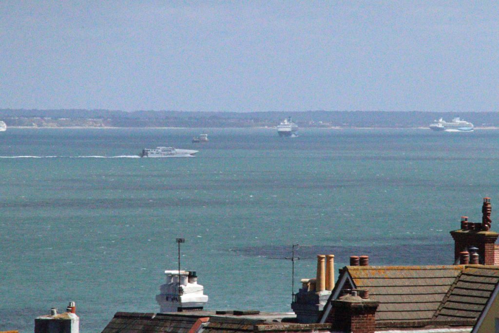 Condor Rapide ferry with cruise ships in background