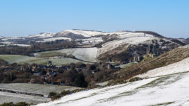 Snow on hills with Corfe Castle