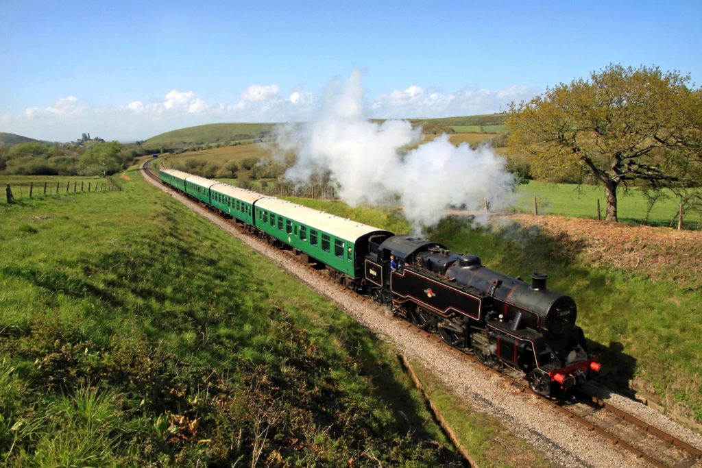 Locomotive pulling carriages through Purbeck countryside