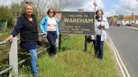 People next to Welcome to Wareham sign