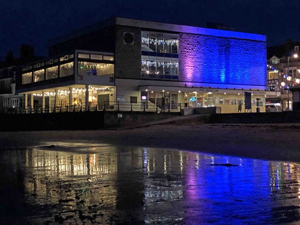 Exterior of The Mowlem lit up in blue