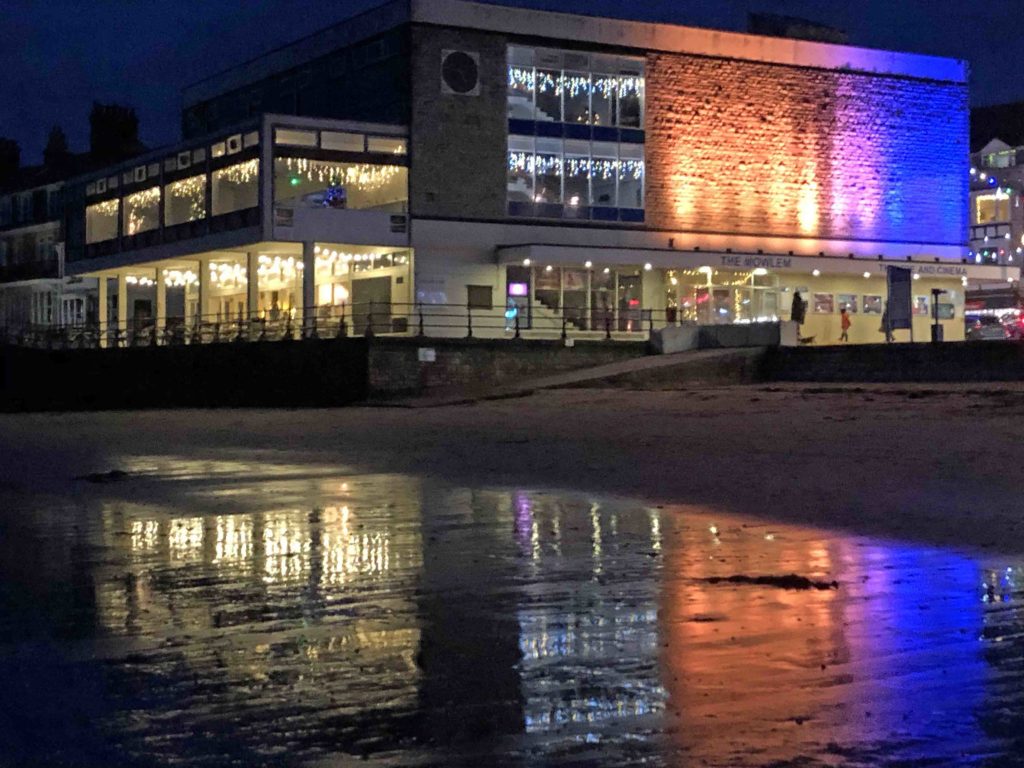 Exterior of the Mowlem lit up in orange and purple