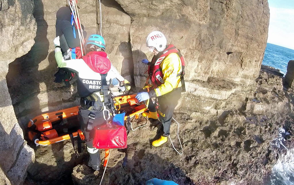 Climber put onto stretcher at bottom of cliff