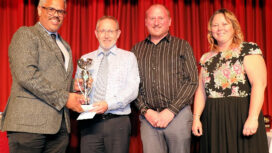 Swanage CC members Craig Wells, Chris Wood and Natasha Norman receive the trophy from Nick Douch