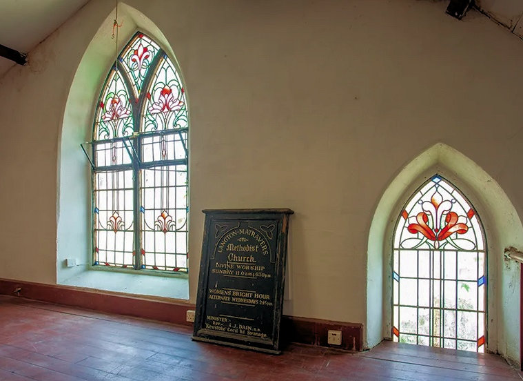 The original chapel stained glass windows and Victorian notice board are features of the home