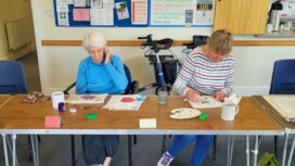 Art workshop members Tricia and Jenny practise painting on silk as their latest project