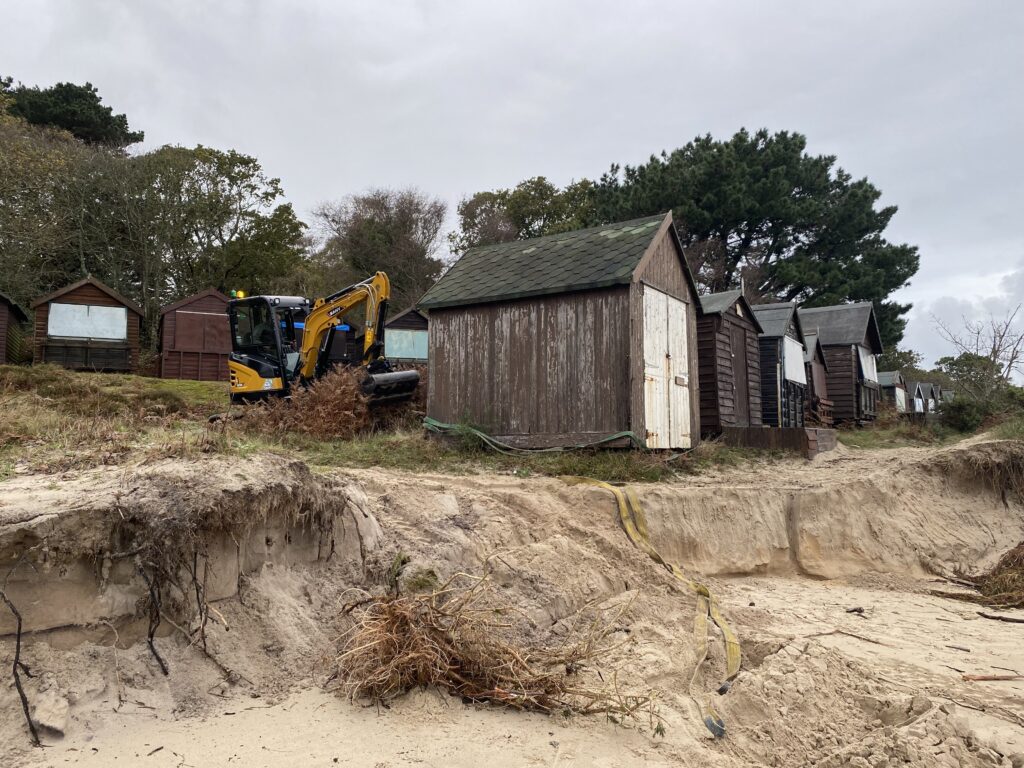 Storm Ciaran - Digger preparing to move a vulnerable beach hut back from edge of collased dune