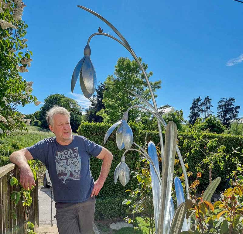 Artist David Hyde with eight foot tall metal snowdrop