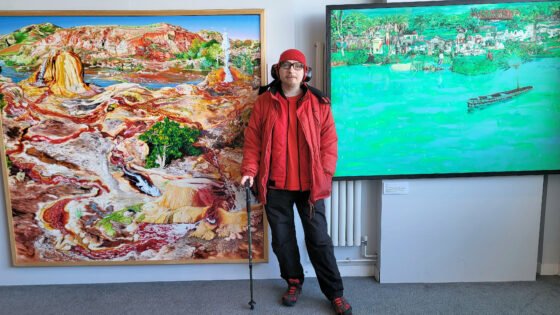 Swanage artist Josh Hollingshead with two of his paintings on display at The Mowlem